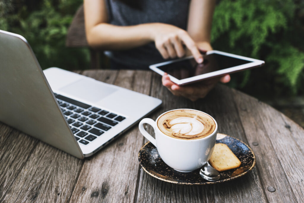 Person Using Tablet Near Laptop Coffee 3 1024x683